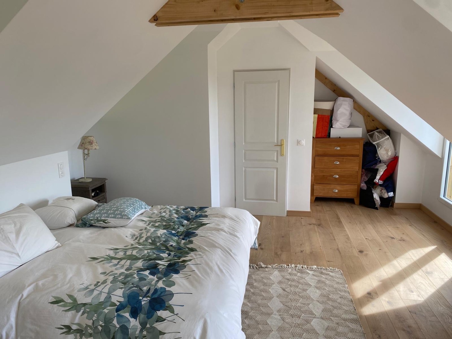 Chambre sous combles avec porte blanche neuve, parquet chêne et charpente apparente